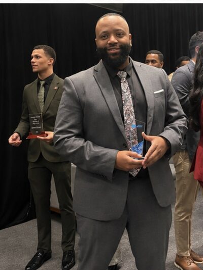 Thierry Hart holding an award at an industry recognition event
