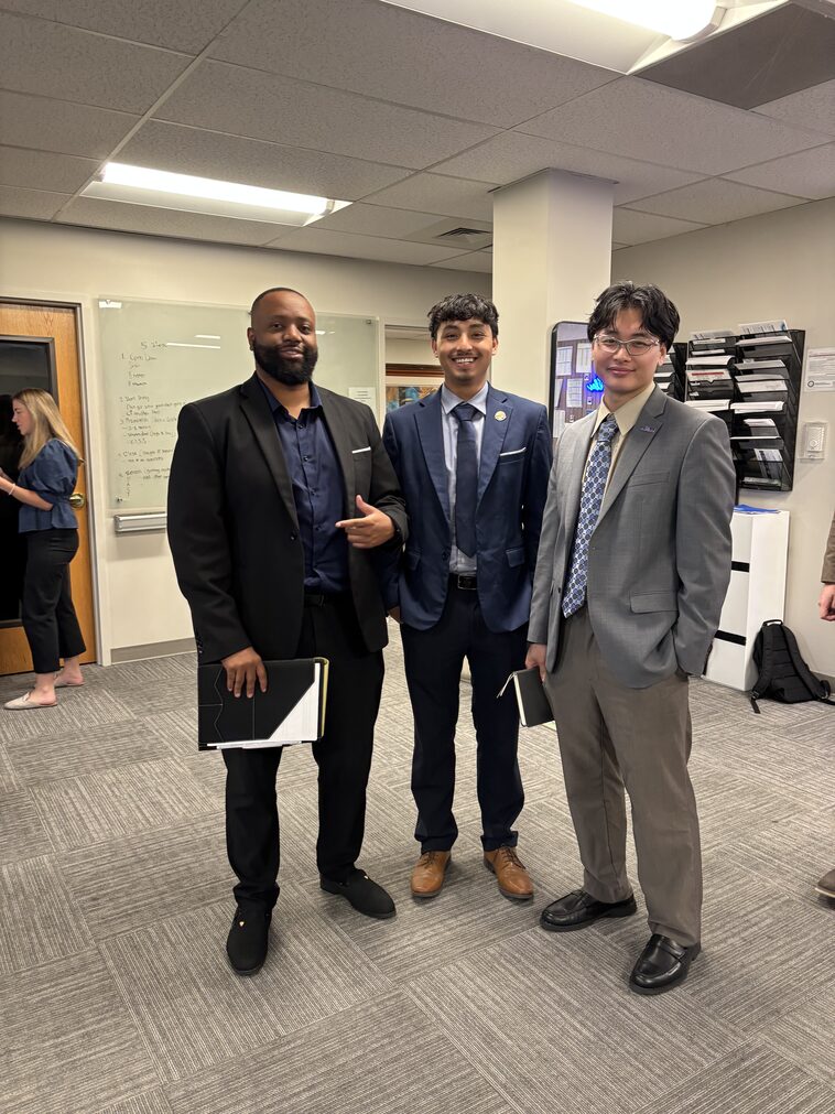 Three Empire Acquisitions representatives suited up in the office before the morning meeting